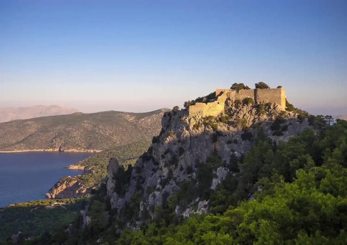 Ruiny zamku Monolithos na szczycie samotnej skały z widokiem na Morze Egejskie na Rodos.
